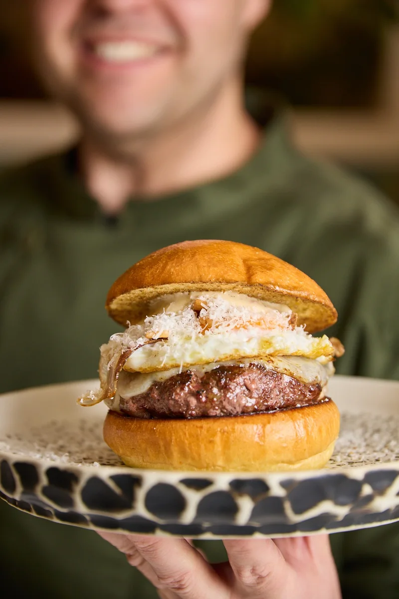 Camarero sirviendo una hamburguesa de autor de Hatillo, Las Rosas