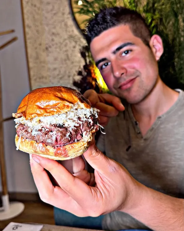 Manu con una hamburguesa de Hatillo, en su reel de Instagram