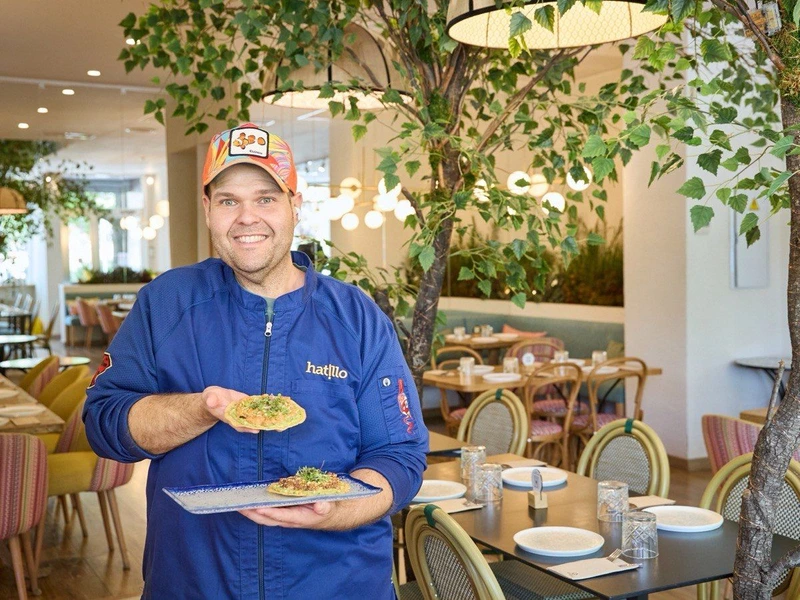 Miguel, de Hatillo, con un plato en la sala del restaurante en Las Rosas